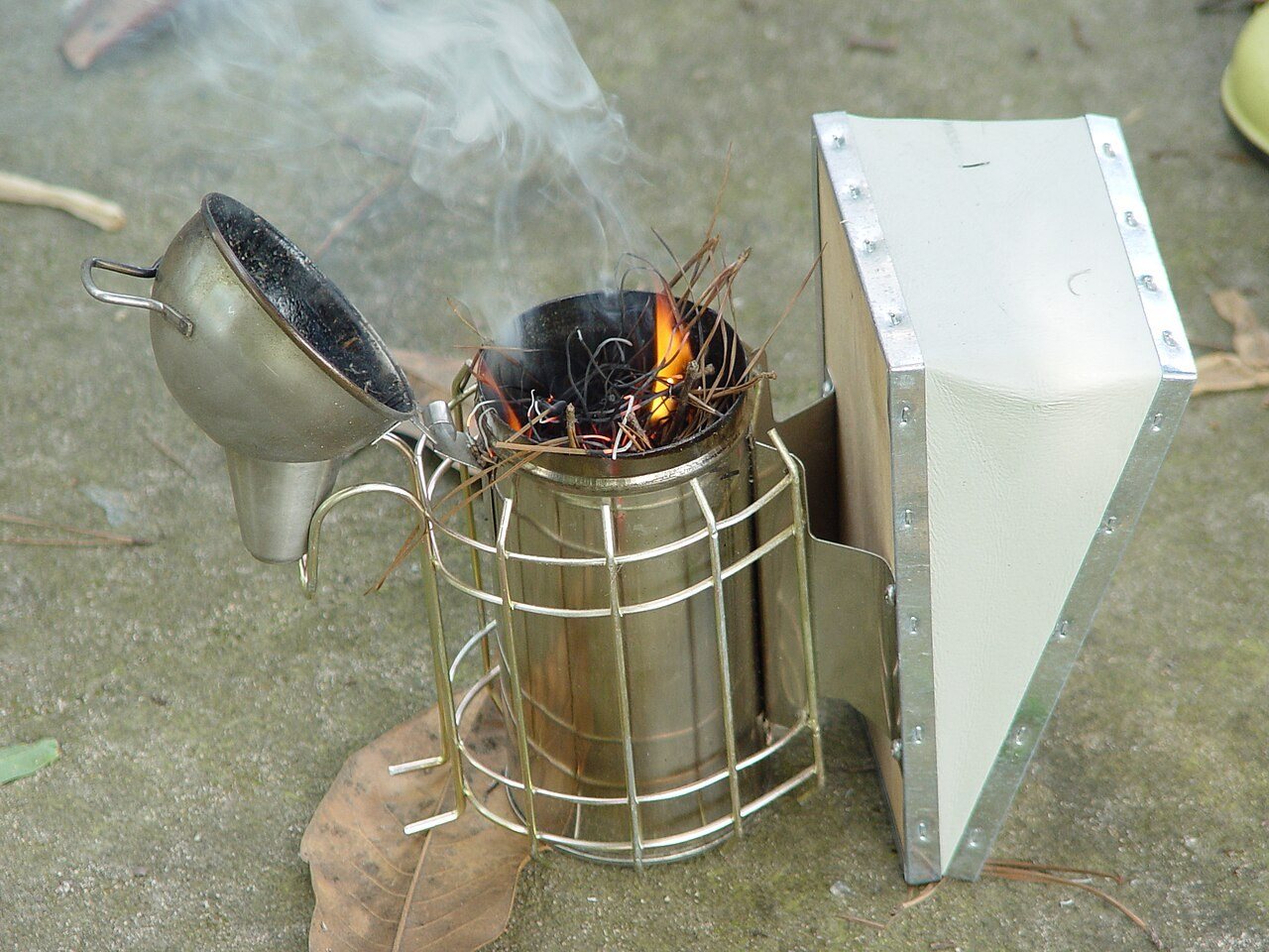 Stainless steel smoker with lit fuel and the lid open