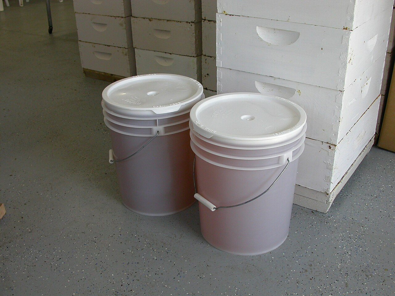 ふたを閉めた2つのプラスチック製ハチミツバケツ