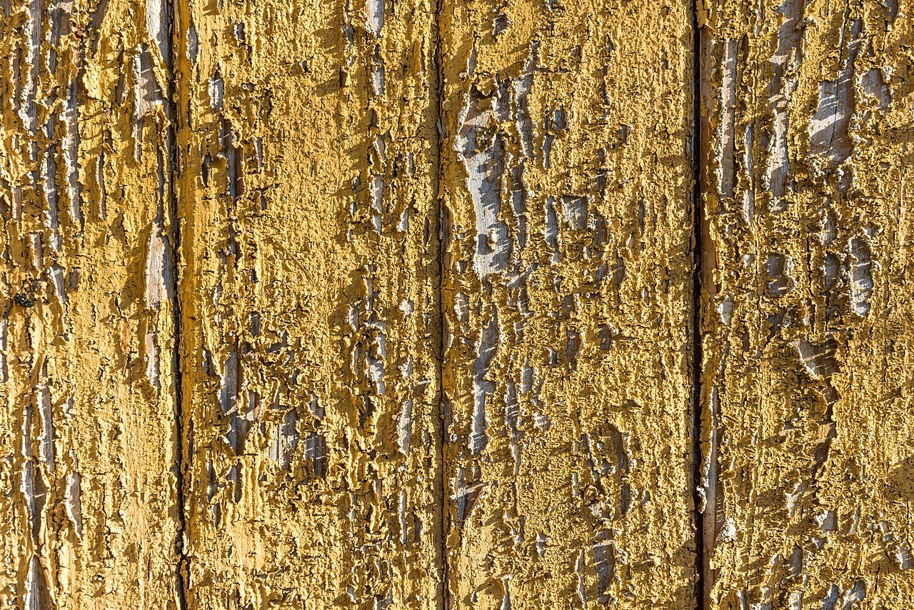 A painted wooden surface cracked and peeling over the years